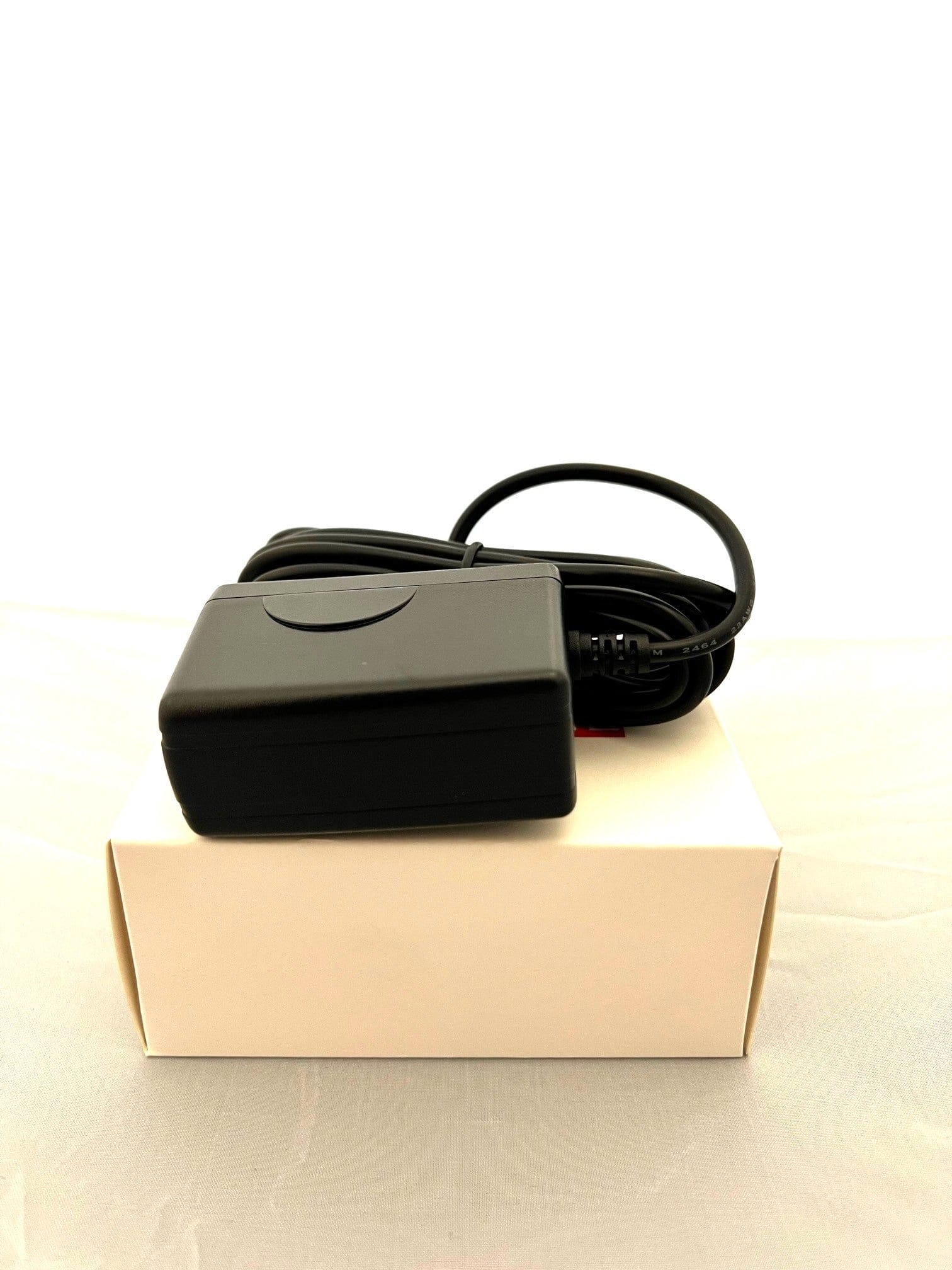 OMNIHIL power adapter connected to Plantronics headset on a desk